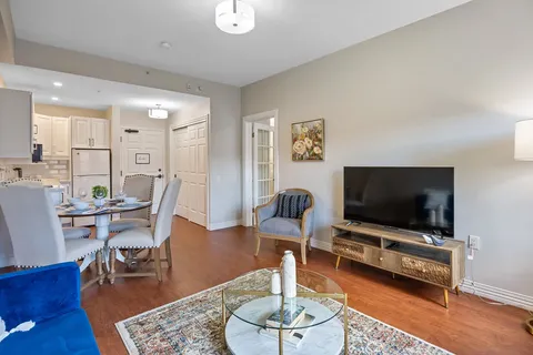Sitting area with a television beside a dining table and kitchenette