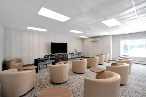 Room with armchairs facing a blank television