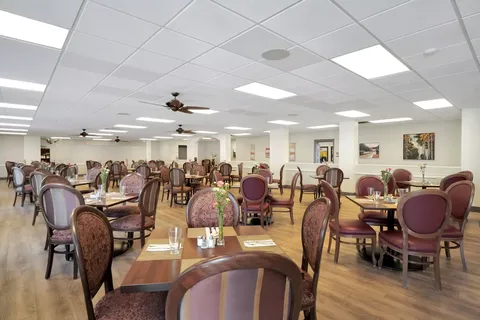Dining room with wooden tables, upholstered chairs and ceiling fans