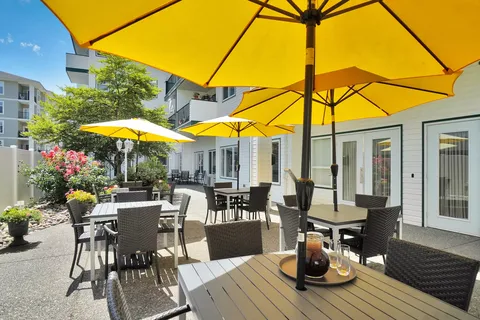 Patio tables and chairs beneath yellow umbrellas