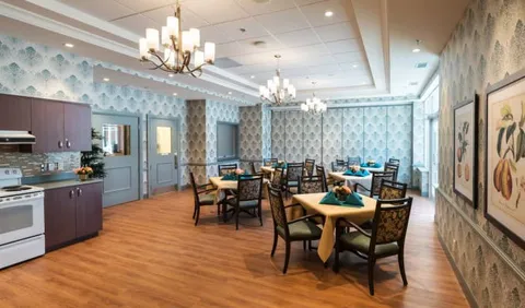 Dining tables and chairs beside cabinets and curtained windows