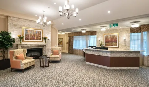 Reception desk beside armchairs, a fireplace and woodland paintings