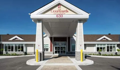 Covered entrance with columns, glass doors and the number 630