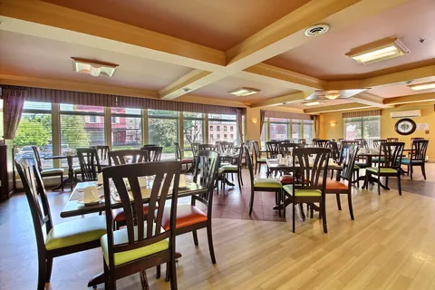 Dining room with wooden tables, chairs and large windows