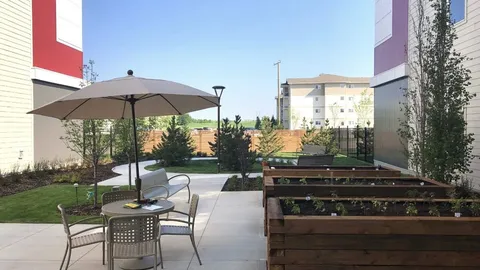 Patio with an umbrella, outdoor chairs and raised garden beds