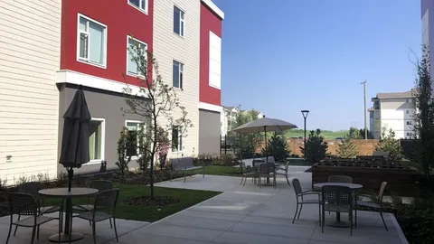 Courtyard with patio tables, umbrellas and raised garden beds