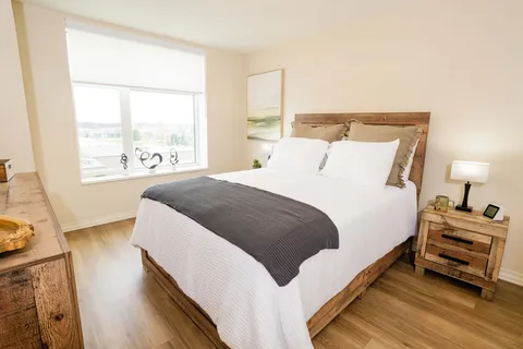 Bedroom with a wooden bed, dark blanket and matching bedside tables