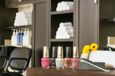 Salon counter with nail polish and styling chairs.