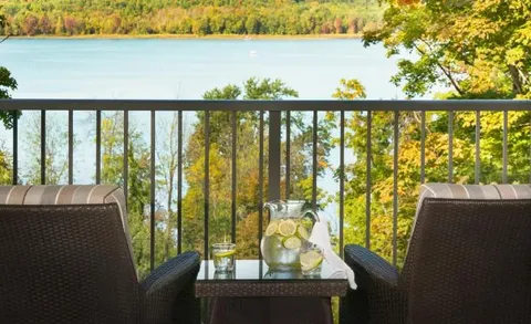 Balcony seating overlooking the lake and trees.
