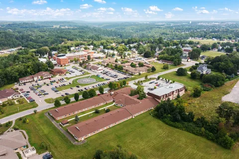 Aerial view of Quail Creek residence with lawns, trees and nearby parking.