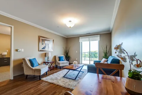 Suite living room with a sofa, armchairs and a patio door.