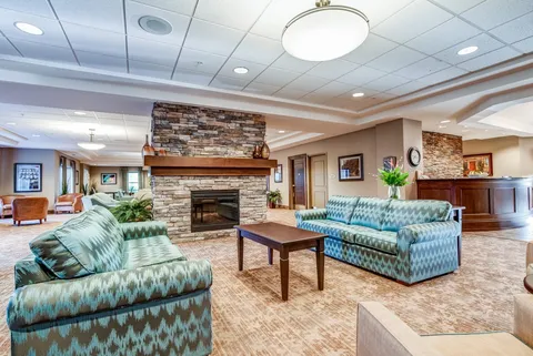 Lounge with patterned sofas and a stone fireplace.