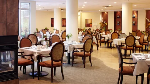 Round dining tables with white linens and upholstered chairs