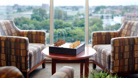 Armchairs around a chess table beside a large window