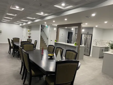 Dining table and chairs beside the kitchen and stairs.