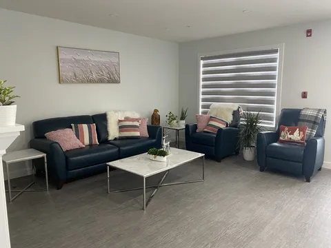 Living room with a sofa, recliners and a window.