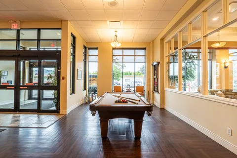 Pool table beside glass entrance doors and large windows