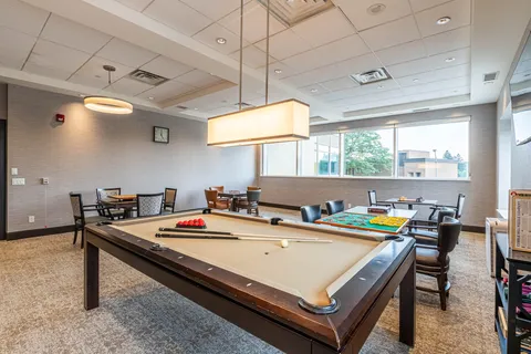Games room with a billiards table, card tables and chairs