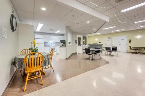 Room with tables, chairs and a grey floor
