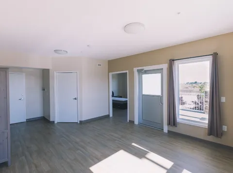 Unfurnished room with wood-look flooring, windows and an open doorway