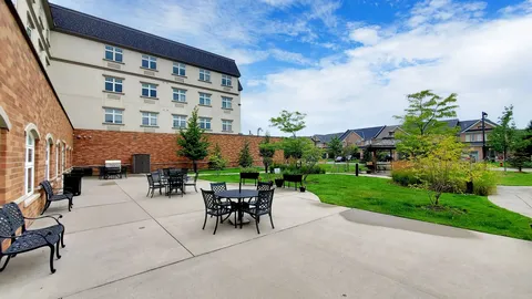 Residence buildings beside a patio with black tables and chairs