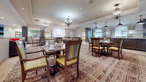 Dining room with set tables, upholstered chairs and chandeliers
