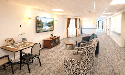 Long lounge with sofa seating, television and dining table.