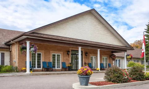 Residence entrance facade with a covered porch and flower planters.