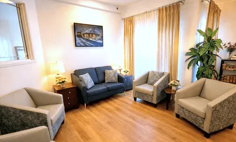 Seating area with sofas, armchairs and large windows.