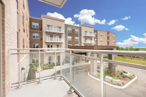 Balcony with glass railings overlooking the residence courtyard.
