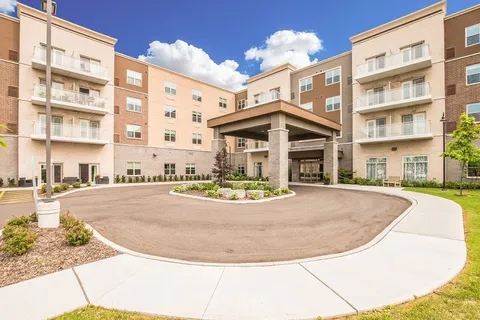 Residence exterior with balconies, covered entrance and circular driveway.