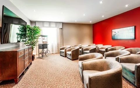 Rows of armchairs facing a large television
