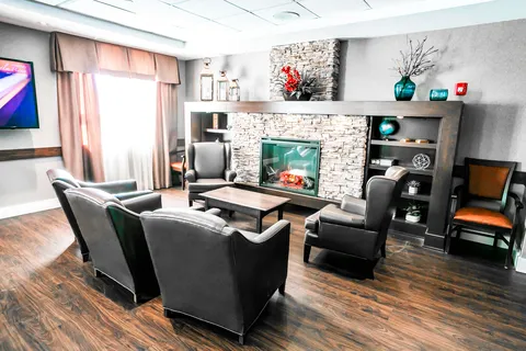 Armchairs around a stone fireplace and shelving