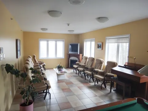 Room with rows of recliners, a keyboard instrument, a fireplace and a television