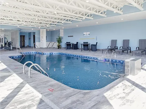 Indoor swimming pool beneath white roof beams