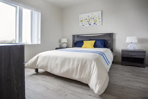 Bedroom with bedside tables, lamps and floral wall art