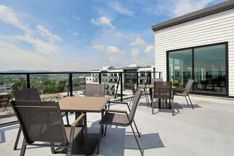 Rooftop patio with tables, chairs and glass railings