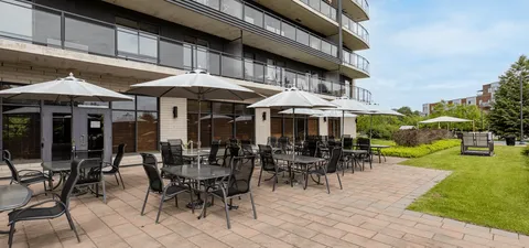 Patio with tables, chairs and umbrellas beside the residence