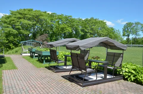 Garden path beside covered outdoor swings and raised planting beds