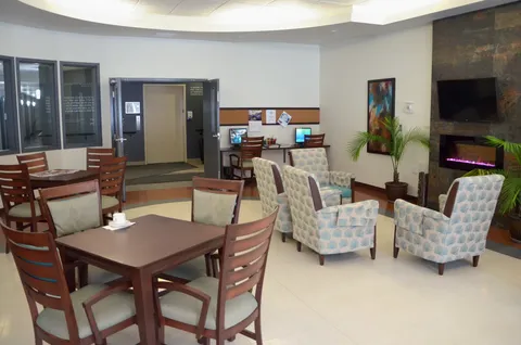 Seating area with patterned armchairs, tables, a fireplace and computers