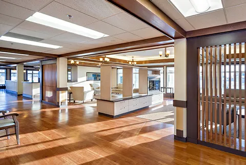 Bright common area with tiled ceiling panels, seating and wood flooring