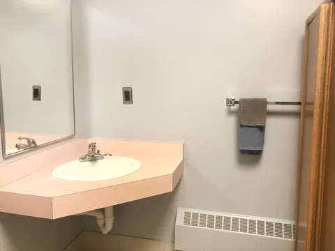 Bathroom sink with a pink counter, wall mirror and towels