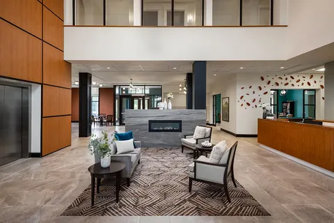 Reception lounge with sofas, chairs and a stone fireplace.