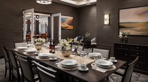 Private dining room with a long set table and wall artwork.