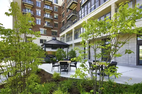 Courtyard with tables, a gazebo and landscaped planting beds.