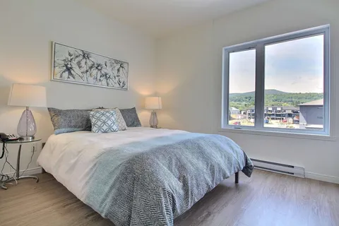 Bedroom with a double bed and a large window.