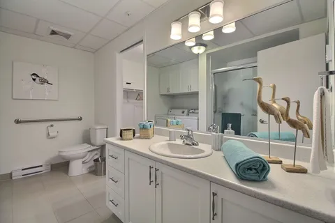 Bathroom with a sink, vanity, toilet and shower.