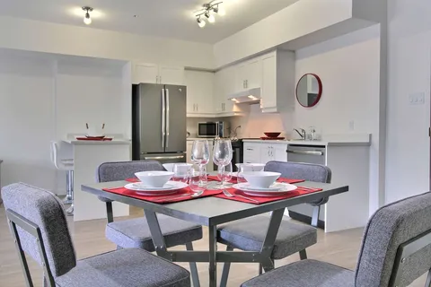 Suite dining table beside a white kitchen.
