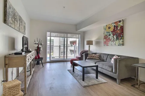 Suite living room with a sofa, television and patio door.