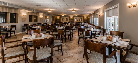 Dining room with wooden tables and upholstered chairs.